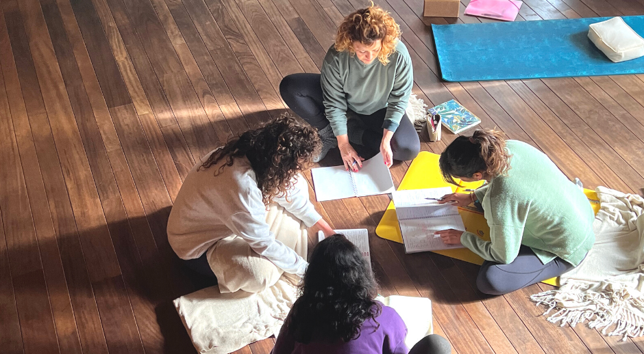 Alumnos estudiando en clase de formación de profesores de yoga